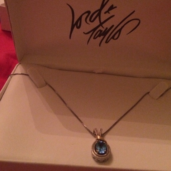 Silver necklace with gold accent and blue stone .