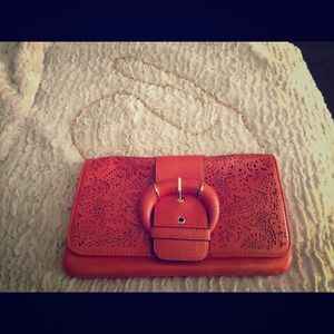 Orange purse with gold chain strap.