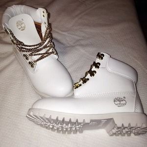 all white timberlands with gold chain 