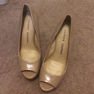 Nude patent leather peep toe pumps.