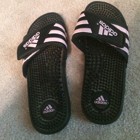 Adidas black and pink striped slides.