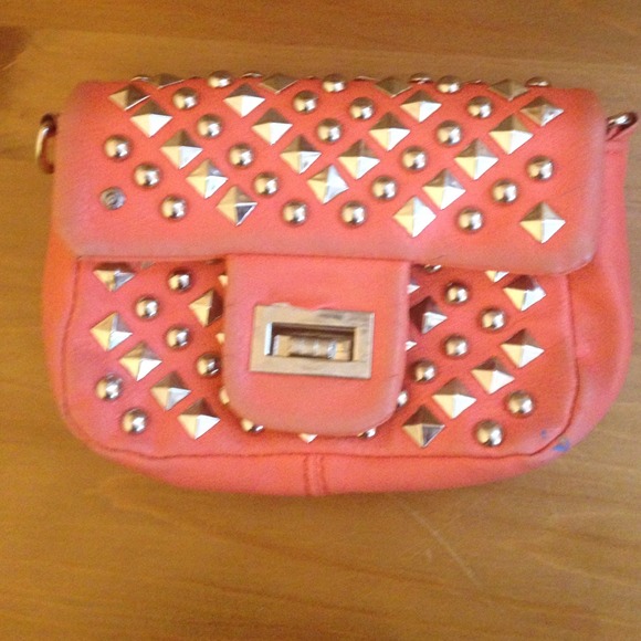 A cute peach/pink clutch purse with studs.