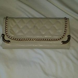 Cream colored clutch with gold chains.