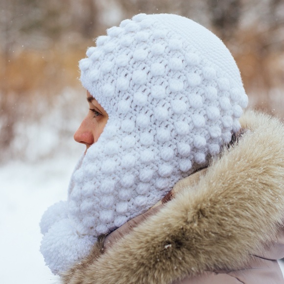 Knitted hat with earflaps and pompons