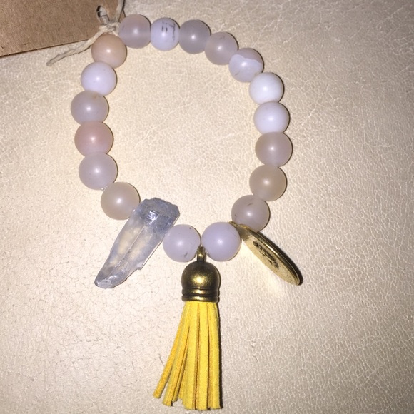 Polished stone bracelet with leather tassel charm