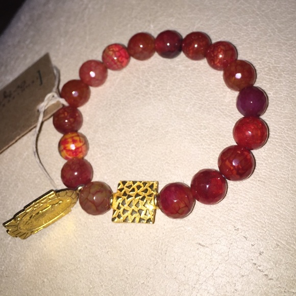 Orange polished stone bracelet with saint charm