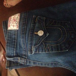 Denim True Religions with orange stitching.