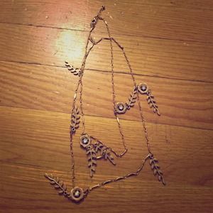 Long gold necklace with leaf and flower details