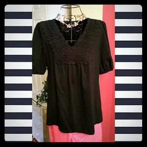 Black top with black eyelet lace embellishment.