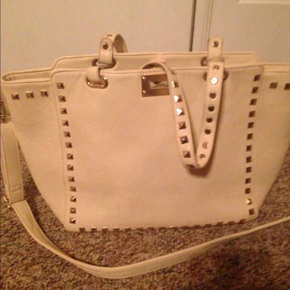 A white leather medium handbag with gold studs.