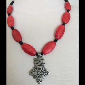Red coral and antique silver charm.