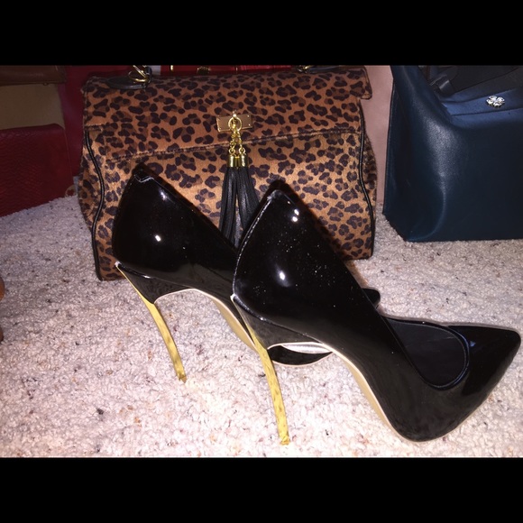 Women's black high heel shoes with a gold heel.