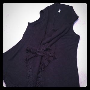 Long black sweater vest with fringe detail.
