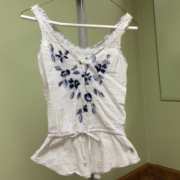 White tank with blue embroidery.