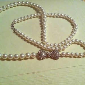 Long pearl necklace with diamond bow