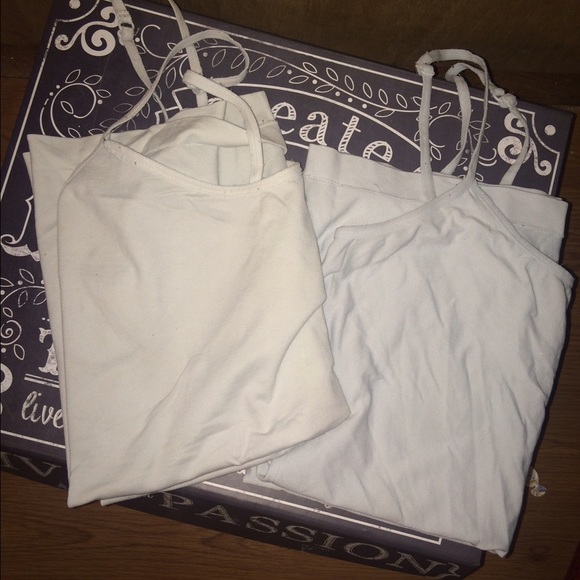 Three white tank tops. One not pictured.