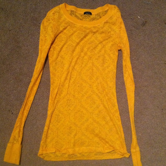 Thin yellow long sleeve shirt w design on it