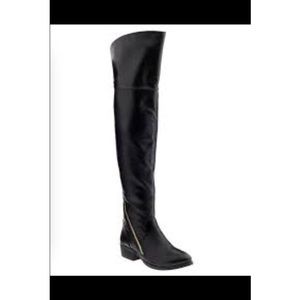 Knee - high feaux leather black boots.