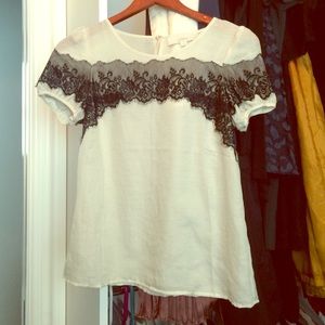 Cream colored blouse with lace overlay.