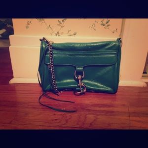 A teal leather purse with and a chain hanger