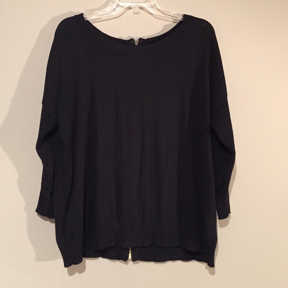 Black top with a gold zipper on the back