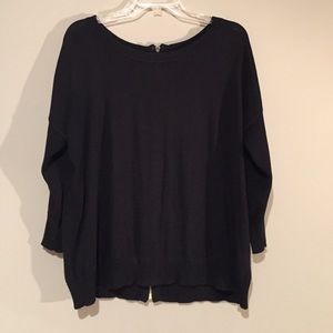 Black top with a gold zipper on the back