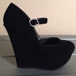 Closed toe black suede wedges.