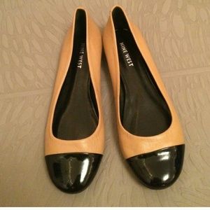 Nude flats with shiny black tips.