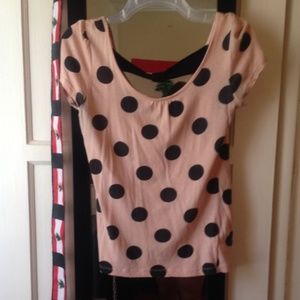 pink shirt with black polka dots on it