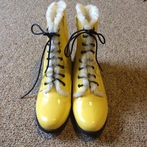 Yellow zip up boots lined with white fur.