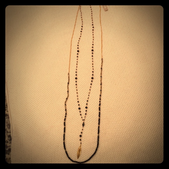 Gold and black beaded necklace with feather charm