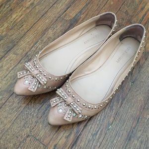 Pointed toe flats with a bow and studs
