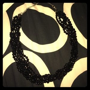 Black beaded, braided necklace.