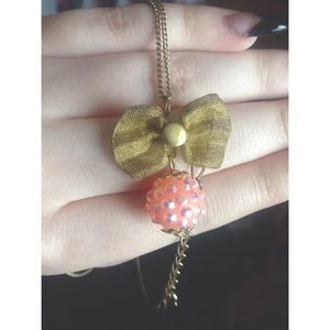 Pink and gold ball and bow pendant necklace