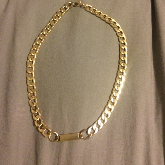 Gold chain necklace with gold bar in the middle.