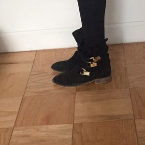 Black ankle boots with gold accessory