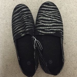 Black and silver zebra print slip on "toms"