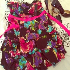 Black, colored strapless dress. Pink sash belt.