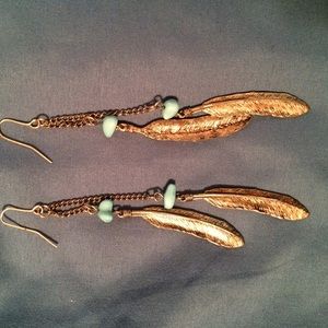 Gold feather earrings with turquoise detailing.