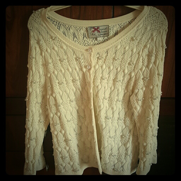 A beige blouse with pearls all over it