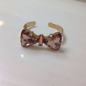 Gold and pink jeweled bow bracelet.