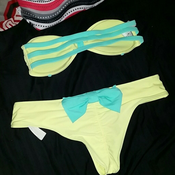 Yellow bathing suit with a teal blue bow.