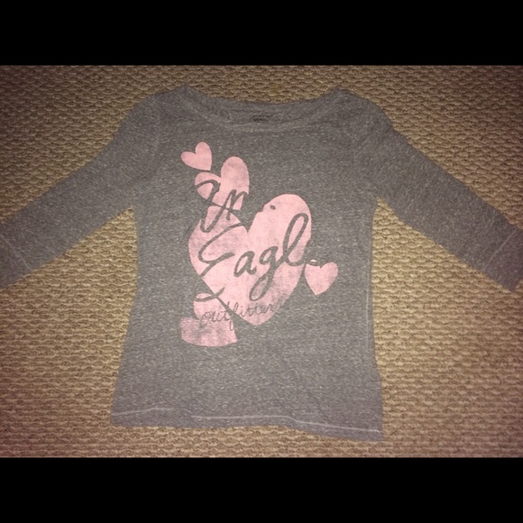A light gray top with pink writing