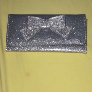 Silver glitter wallet with a bow.