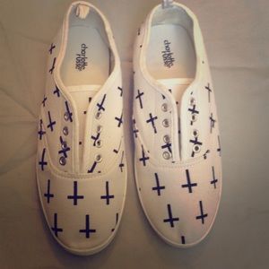 White slip on shoes with black cross designs