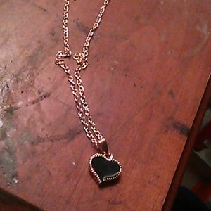 A gold chain with a gold and onyx heart