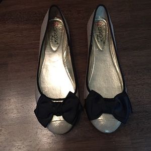 Really cute gold ballets with a black bow