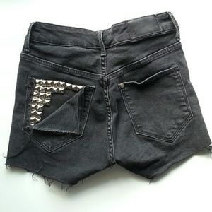 Studded, distressed black denim shorts.