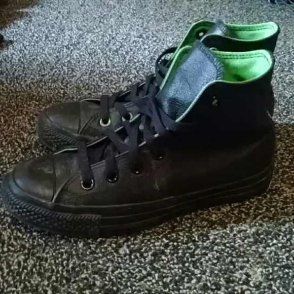 Black leather converse with some green.