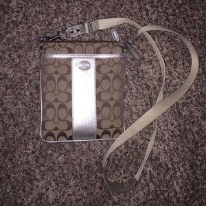 Gently used coach cross body bag in gold.